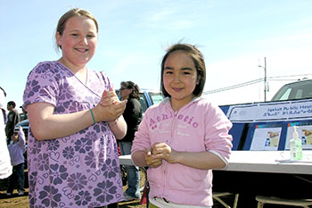 Eleven-year-old Stephanie Bloor and nine-year-old Alannah Maloney clean their hands with sanitizer supplied by GN public health workers outside the Alianait tent on June 21, National Aboriginal Day. (PHOTO BY JIM BELL)