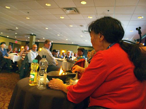 Members of Nunavut's district education authorities watch the lighting of a qulliq before the start of a three-day training workshop on the new Education Act in Iqaluit Tuesday. 