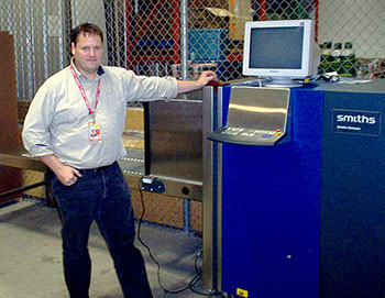 John McPhee, manager of Kivalliq Air, stands next to the airline company's new X-ray machine in Winnipeg. Passengers on Kivalliq Air will now see their baggage and cargo shipments X-rayed, part of an effort to clamp down on transports of drugs and alcohol to Kivalliq communities. (PHOTO COURTESY OF KIVALLIQ AIR)