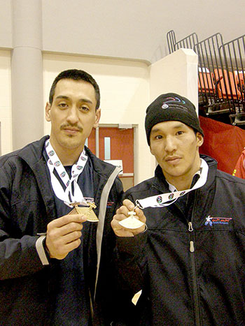 Sean Nipisar, left, of Whale Cove and James Qajaaqjuaq Tautu of Chesterfield Inlet pose with their gold ulus. Nipisar won gold in the two-foot high kick while Tautu took the gold for kneel jump in the open male competition. (PHOTO BY DAVID JOANASIE/CLEY)