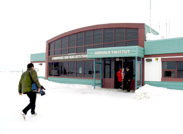  A passenger walks toward the terminal building at Cambridge Bay's airport in April, 2010. A new report says the airport “urgently” needs millions of dollars of upgrades, including a paved runway and extended terminal building. (PHOTO BY CHRIS WINDEYER)