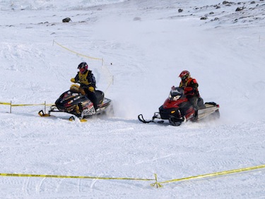 Snowmobilers battle for position coming out of a corner during uphill climb races near the Arctic Winter Games Arena in Iqaluit April 15. The races were part of Toonik Tyme, which continues this week. (PHOTO BY CHRIS WINDEYER)