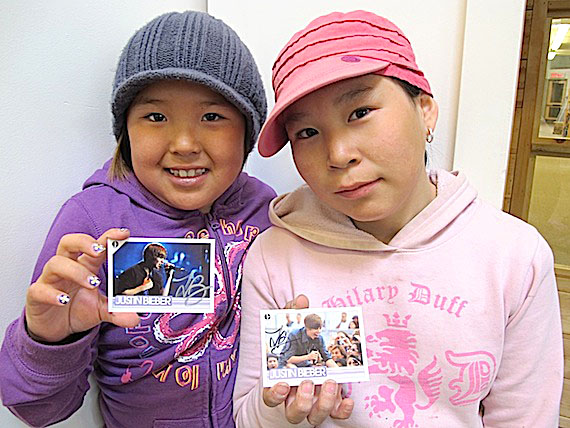 Ashley Evalik, left, and Alice Evetalegak, right,  recently took part in a letter-writing activity to pop singer Justin Bieber at Cambridge Bay’s May Hakongak Library. The girls, who sent letters to Bieber's record label company in New York, received autographed JB cards, displayed here. (PHOTO COURTESY OF THE KITIKMEOT HERITAGE SOCIETY)