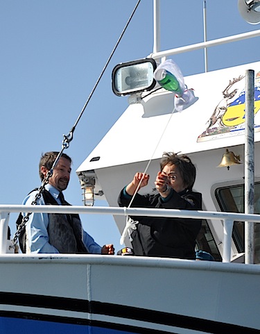 Nunavut premier Eva Aariak gets ready to throws a bottle of sparkling water against the hull of the MV Nuliajuk July 11 to christen the new research vessel anchored off Iqaluit. (PHOTO BY SARAH ROGERS)