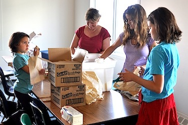 Volunteers help gather food items from Niqinik Nuatsivik’s storage and distribution facility, which is shared with the community’s soup kitchen. The food bank counts about 70 volunteers. (PHOTO BY SARAH ROGERS)
