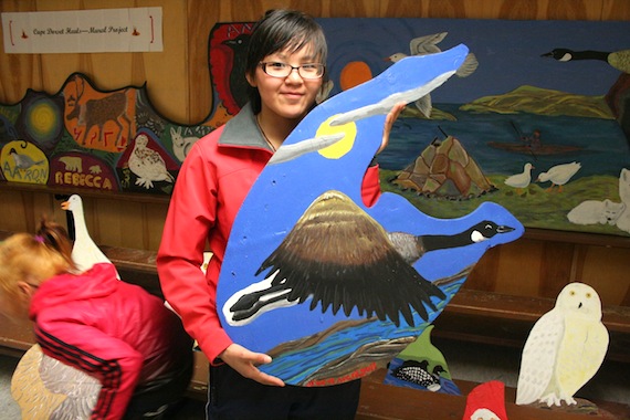Neevee Jaw, who spent the summer as a mental health intern, helped organize a week-long activity with youth at Cape Dorset's arena, where they painted different species of Arctic birds on scraps of plywood donated from construction sites around town. Jaw produced two paintings of her own, both of Canada geese. In one, shown here, a goose flies under a full moon partially veiled by thin wispy clouds. (PHOTO BY JUSTIN NOBEL)