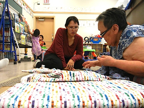 Michelle Maniyogena and Margaret Okina discuss how to cut a piece of cloth. Pregnant women and young mothers regularly get together with elders for sewing sessions organized by the Wellness Centre in Cambridge Bay. (PHOTO BY JANE GEORGE)