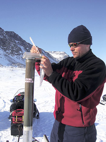 A researcher takes an ice-core sample from a site on Baffin Island in 2005. (FILE PHOTO)