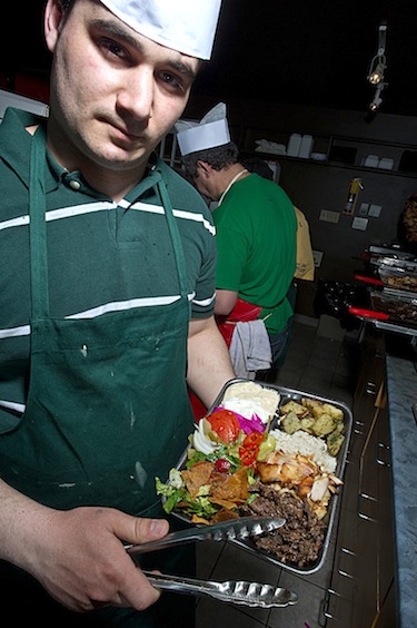 Khldoun El-Shamaa of Yummy Shawarma holds up a finished plate of Lebanese specialties. (PHOTO COURTESY OF YUMMY SHAWARMA)