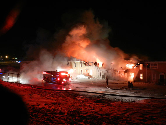 Firefighters struggle to contain a fire in a rowhouse unit at the end of the 300-section of the Creekside Village complex in downtown Iqaluit shortly after midnight on Feb. 27. (PHOTO BY JIM BELL)