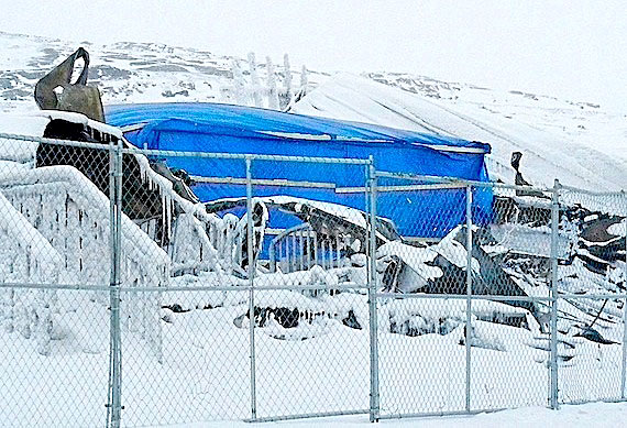 Two weeks after the disastrous fire that left 83 homeless and killed two, the scene of the Feb. 26 Creekside Village fire, shown here March 10, is circled by a metal fence, while a blue tent protects part of the burned shell from the elements. The RCMP, along with the Nunavut’s Fire Marshal’s office and fire investigators from Saskatchewan, continue their investigation into the fire. Meanwhile, fundraising efforts also continue for the victims of the fire, with Iqaluit's Joamie elementary school recently raising more than $5,000. Read the latest about the Feb. 26 fire at Nunatsiaqonline.ca. (PHOTO BY JANE GEORGE)