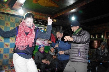 David Iqaqrialu and Shari Gearheard dance with their guide Dhawa Lama to traditional music after dinner with their local hosts in Tsum. (PHOTO BY HENRY HUNTINGTON)