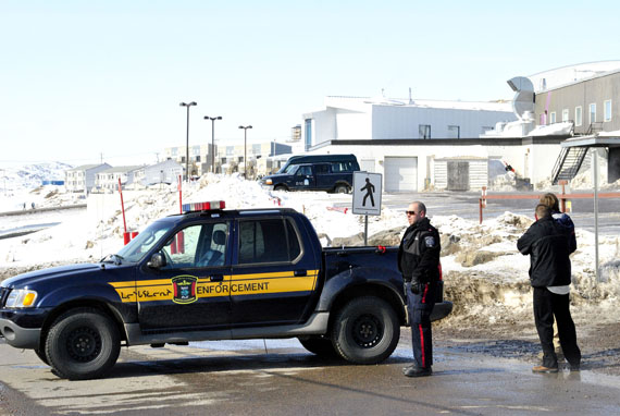 An Iqaluit bylaw officer maintains a roadblock on Apex Road at around 2:00 p.m. April 19 during an incident in which a man armed with a rifle was holed up inside the lobby of the new Qikiqtani General Hospital building. The man, who entered the hospital lobby around 12:50 p.m. was arrested by 2:40 p.m. No one was injured. (PHOTO BY JIM BELL)