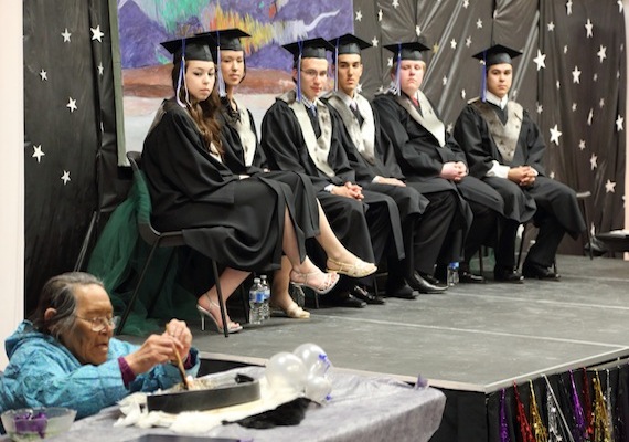 Cambridge Bay high school graduates Kati Omilgoitok, Melynda Minilgak, Ryan Gillis, Audla Buchan, Neil Bligh and Tyler Angulalik watch elder Lena Kamoyak light the qulliq as the May 26 graduations ceremonies at Kiilinik High School start. (PHOTO BY RED SUN PRODUCTIONS)