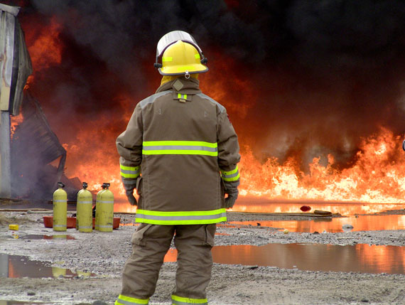 A firefighter stands, at around 7:15 a.m. June 8, before a huge fire that consumed a hamlet garage in Arviat. Firefighters were alerted to the blaze at around 6:30 a.m. The cause of the fire is unknown. (PHOTO COURTESY OF JORDAN KONEK)