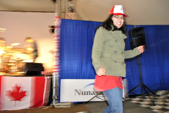 Emcee Jesse Fraser dances to the music of Rankin Inlet's Esther Powell and the Rough Cuts at a Canada Day show July 1 in Iqaluit inside the Alianait festival's big top tent. Despite cool temperatures and overcast skies, hundreds of Iqaluit residents flocked to Nakasuk School to enjoy Canada Day. (PHOTO BY JIM BELL)