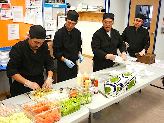 A line of students from Nunavut Arctic College's camp cook program in Cambridge Bay prepare a wrap stuffed with pulled pork during the program's popular lunch hour 