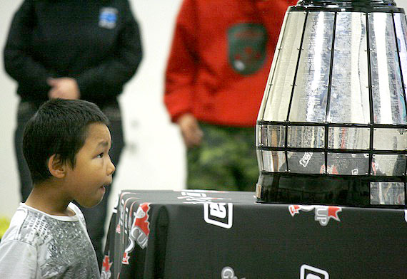 An Iqaluit boy looks at the Grey Cup at a free community event Oct. 11 inside Nakasuk School, where people enjoyed live folk music and posed for photos with the trophy, awarded every year to the top team in the Canadian Football League. The cup, which is on a 100-community journey across Canada, arrived in Iqaluit Oct. 11 and is leaving on Oct. 12. Read more about where the Grey Cup went while in Iqaluit on Nunatsiaqonline.ca. (PHOTO BY DAVID MURPHY) 
