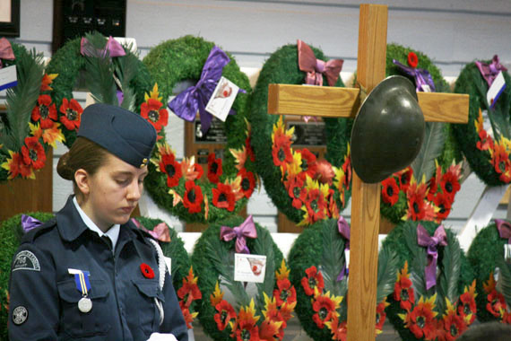 Warrant officer second class Amy Clark of the Iqaluit air cadets squadron pays her respects beside dozens of wreaths laid by Iqaluit residents at a Remembrance Day ceremony Nov. 11 in the Cadet Hall. The ceremony included reading of the poem, 