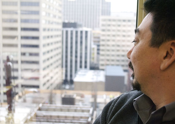 Terry Audla peers through his office window Dec. 13 to view a typical downtown Ottawa cityscape: “I miss the deafening silence. As we sit here right now, we can hear traffic, we can hear construction.” PHOTO BY BRIELLE MORGAN)