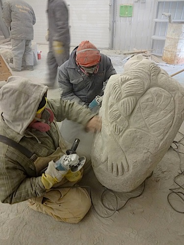 Salomonie Pootoogook  and Abraham Eetak work on a carving inspired by Sedna at NACA’s Arviat granite stone carving symposium. (PHOTO COURTESY OF NACA)