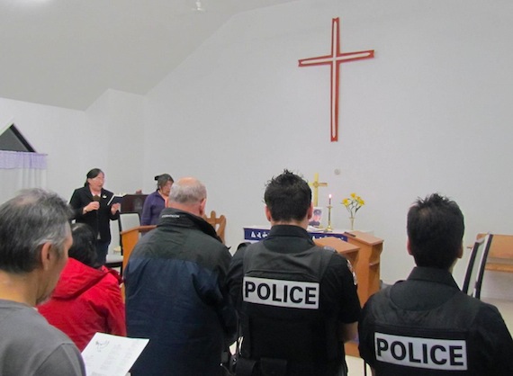 Members of the Full Gospel and Anglican congregations in Kangirsuk say a prayer with police March 6 at a memorial service for Steve Dery, a constable with Nunavik's police force who was killed March 2 in Kuujjuaq when he responded to a domestic violence call. Dery served in Kangirsuk in 2009. (SUBMITTED PHOTO)