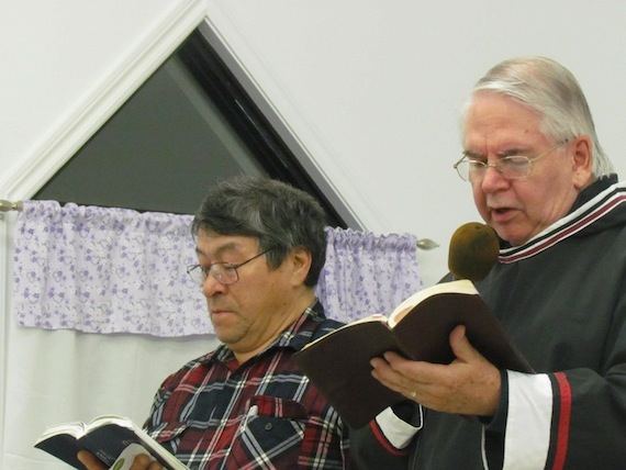David Ellyatt, right, says a prayer for police and front-line workers, social workers and nurses, with Zebedee Nungak, at left, during a memorial service March 6 for the late Cst. Steve Dery, a constable with Nunavik's Kativik Regional Police Force who was killed March 2 in Kuujjuaq when he responded to a domestic violence call. Dery served in Kangirsuk in 2009. (SUBMITTED PHOTO)