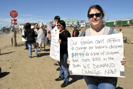 Food price protestors stand across the street from Iqaluit’s Northmart store last August. (FILE PHOTO)