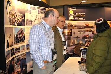 Brooke Clements, left, and Tom Peregoodoff of Peregrine Diamonds Ltd. speak April 10 to Nunavut Tunngavik Inc. president Cathy Towntongie at the Nunavut Mining Symposium trade show at the Frobisher Inn. (PHOTO BY JANE GEORGE)