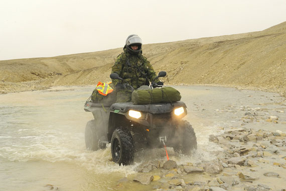 An Operation Nanook live fire range reconnaissance patrol near Resolute Bay led by Capt. Simon Turrel on Aug. 6. Transport Sgt. Cedric St-Pierre from 35 Brigade Headquarters Arctic Response Company Group crosses the shallow river that runs along the range, testing the depth. (PHOTO BY CPL. DAN STROHAN, 8 WING IMAGING TRENTON)