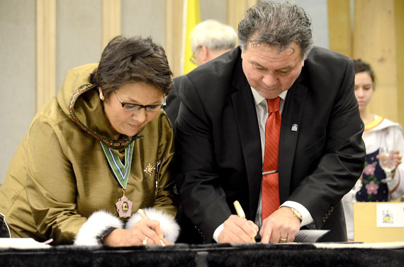 Nunavut Commissioner Edna Elias and the newly elected premier, Peter Taptuna, sign a document that officially makes him an MLA of the fourth Nunavut Legislative Assembly, at a ceremony in Iqaluit Nov. 19, when MLAs took oaths of office. (PHOTO BY DAVID MURPHY)
