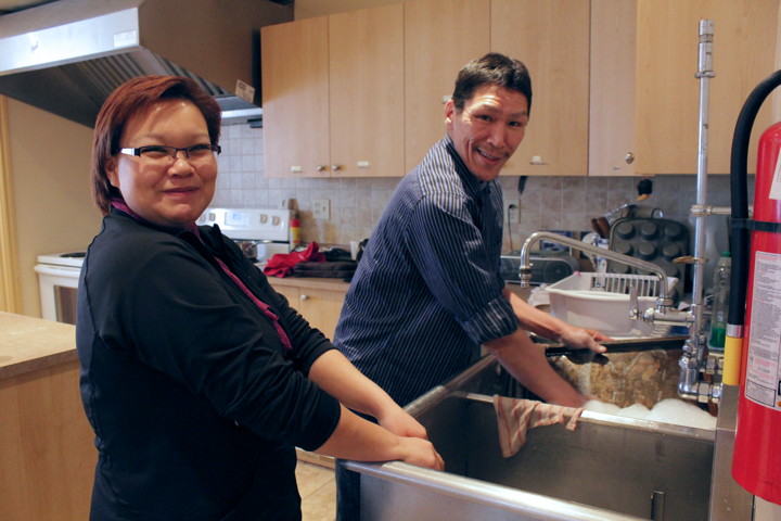 Colleen Ulayuruluk and Danny Napachee in the Mamisarvik kitchen. It was Napachee's turn to clean up after lunch Dec. 6. Residents who are physically able share cleaning duties through the week and cooking duties as well on the weekend, when there is no staff cook. (PHOTO BY LISA GREGOIRE)