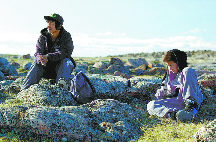 Uvanga characters Travis (left) played by Travis Kunnuk and Tomas (Lukasi Forrest) reflect at the site of their father’s death in the new Arnait Video Productions film. (PHOTO COURTESY OF ARNAIT VIDEO PRODUCTIONS) 