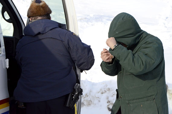 Billy Iblauk, 28, shields his face while leaving the Nunavut Court of Justice April 15. Iblauk's first trial wrapped up April 15, but he faces another trial involving two child complainants April 16. (PHOTO BY DAVID MURPHY)