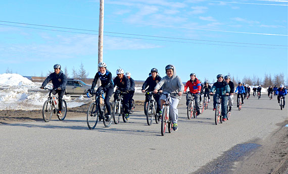 Mental health advocate Clara Hughes, a former Olympian cyclist and speed skater, rides through Kuujjuaq April 30, accompanied by KRPF cadets and other Nunavimmiut youth. As part of her 12,000-kilometre, 95-community tour called Clara's Big Ride, Hughes is cycling across the country to try to remove the stigma that surrounds mental illness. Hughes heads to Iqaluit May 1. (PHOTO BY ISABELLE DUBOIS)