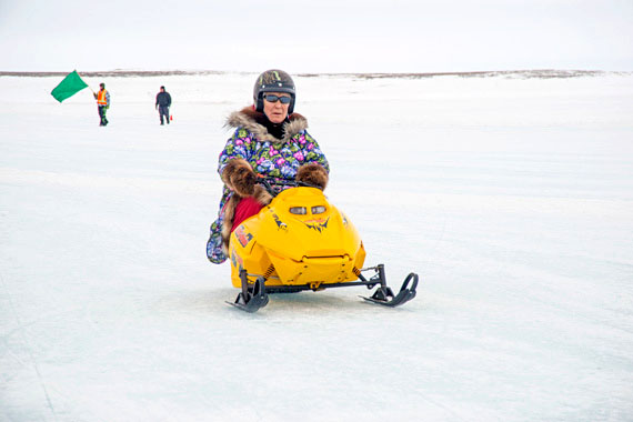 Bessie Omilgoetek rides to a second-place finish in the elders snowmobile race in Cambridge Bay May 17. The race is one of many events hosted in the Kitikmeot community over the long weekend as part of its Omingmak Frolics festival, which wrapped up May 19. (PHOTO BY DENISE LEBLEU IMAGES)