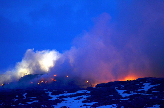 Iqaluit's perpetual dump fire early in the morning of May 22, just after midnight. City of Iqaluit crews have been digging fire-break trenches around the smouldering mess but have given up efforts to put out the fire — because water trucks are needed to deliver water to homes on trucked service. (PHOTO BY DAVID MURPHY)
