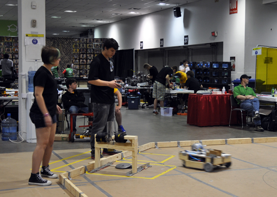 Iqaluit’s Skills Nunavut robotics club members Matilda Pinksen, left and Izaac Wilman steer their teams’ homemade robot through a giant crokinole board. (PHOTO BY SARAH ROGERS) 