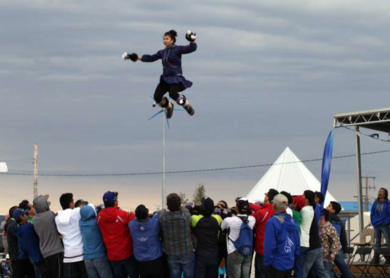 An Alaskan performer flies high through the air in Inuvik, Northwest Territories, as part of a cultural demonstration at this week's Inuit Circumpolar Council's general assembly. The Alaskan blanket toss, or nalukataq, was traditionally used by the Inupiat to give hunters a high vantage point to see check for whales ahead of the spring hunt. The ICC assembly wraps up July 24, with the presentation of the meeting's Kitigaaryuit declaration. (PHOTO COURTESY OF MAKIVIK CORP)