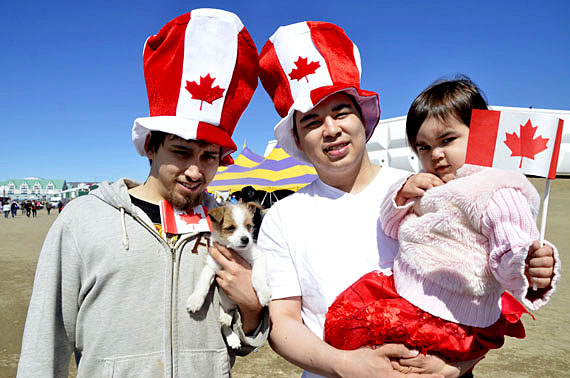Iqalummiut celebrate a gorgeous Canada Day outside Alianait's big top tent in Iqaluit July 1. From left to right: Chris Guimond, puppy Cosmo, Wager Ford and two-year-old Maria Nowdluk. Nunatsiaq News wishes its readers a happy Canada Day — our office will reopen July 2. (PHOTO BY DAVID MURPHY)