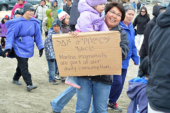 Louise Flaherty was one of more than 100 people who took to the streets of Clyde River July 23 to protest plans for seismic testing in Baffin Bay and David Strait, recently approved by the National Energy Board. The Clyde River-based Fight Against Seismic Testing, which organized the protest locally and throughout the territory, says that seismic testing activities could have severe impacts on marine life and the traditional Inuit lifestyle. (PHOTO COURTESY OF NICK ILLAUQ) 