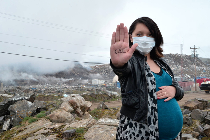 Iqaluit's Julie Alivaktuk is expecting her first child in 10 days. She's frustrated with how smoke from the dump is impacting her health and worries about how it will affect her baby. The word on her hand reads, 