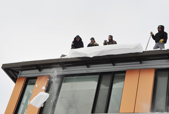 Friends in high places: workers shovel off a snow drift overhang on top of the Kativik Regional Government offices in Kuujjuaq Nov. 24. The forecast calls for more snow and flurries in Nunavik's largest community over the next couple of days. (PHOTO BY SARAH ROGERS)