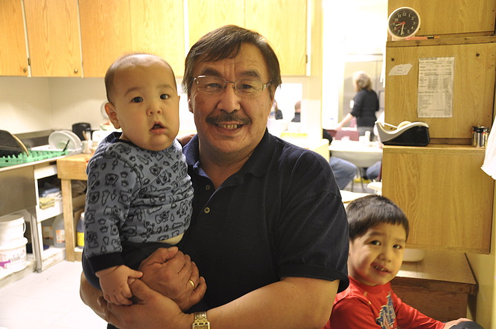 Elijah Evaluardjuk poses with two of his grandsons — Ryland (7 months old) and Roberto (3 years old) Qaunaq — in the kitchen of his family-run Tujurmivik Hotel. (PHOTO BY THOMAS ROHNER)