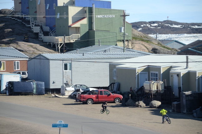 Two kids on bikes play on a street in Iqaluit—without helmets. (PHOTO BY DAVID MURPHY) 