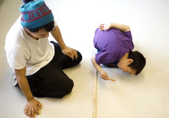 Knowledge sharing from one generation to the next: Marcus Tulugak, a student at Puvirnituq's Iguarsivik School, coaches a young boy from Ikaarvik School, also in Puvirnituq, during the traditional Inukshuk Games, held June 16 and June 17 in this Hudson Bay community. The crowning of the king and queen of the games marked the start of two fun-filled days which featured 15 teams with youth ranging from Kindergarten to Grade 12 competing in 15 different activities. Satisfied staff and students headed home after sharing a closing feast and applauding the award winners and price recipients. (PHOTO BY ALAIN CLOUTIER)