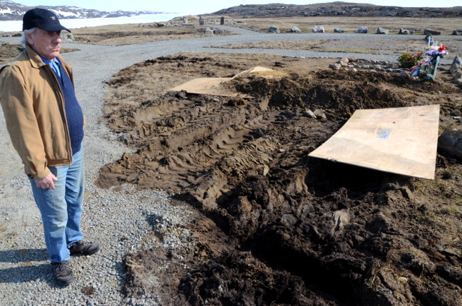 Bryan Pearson surveys the chewed up ground next to three recent burials at Iqaluit’s new cemetery in Apex. (PHOTO BY DAVID MURPHY) 