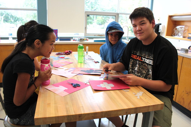Yavuz Sundu, 16, right, used to attend the OICC summer day camps. Now he's a youth worker helping to run them.