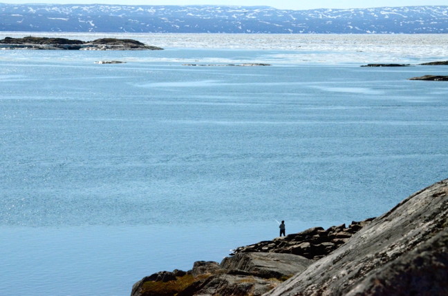 Gone fishin’! Iqalungmiut took time off on a lovely July 23 afternoon to fish near the causeway area. Fishing season, as well as mosquito season, has kicked off in Nunavut’s capital. Ice near the city is clearing but there’s still a massive iceberg blocking the mouth of Frobisher Bay which is preventing supply ships from entering Iqaluit according to the Canadian Coast Guard. But who needs sealift orders when you can head to the bay and catch fresh char? (PHOTO BY DAVID MURPHY)