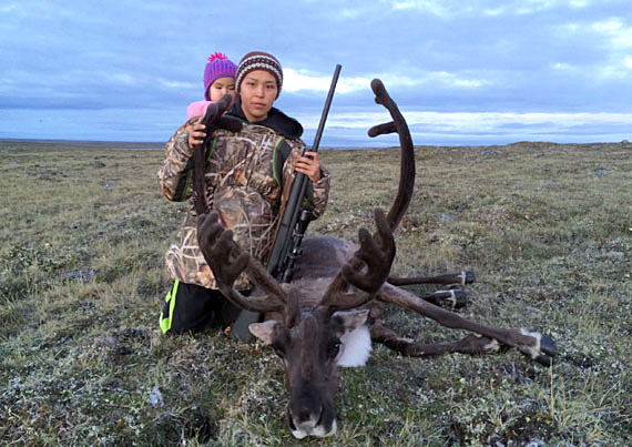 Tanisha Pudlat celebrates her first caribou, caught outside of Rankin Inlet July 28, with the moral support of her one-and-a-half-year-old daughter, Ariana, on her back. The Qamanirjuaq caribou herd is on its annual migration through the Kivalliq region right now. (PHOTO BY NOEL KALUDJAK)